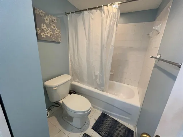 a white toilet sitting next to a bath tub
