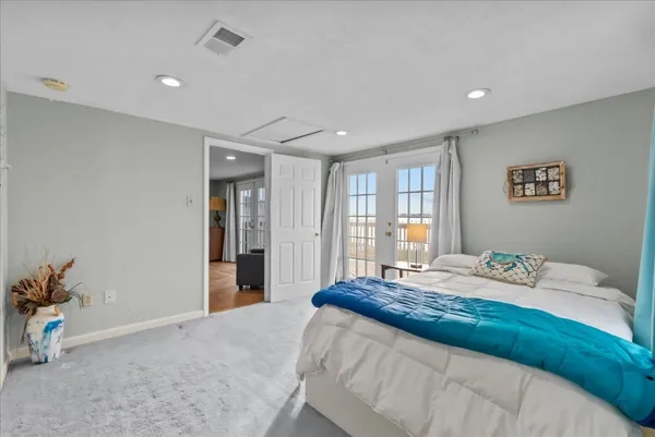 a spacious bedroom with a large bed and a potted plant
