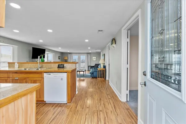 a kitchen with stainless steel appliances kitchen island wooden floors and wooden cabinets