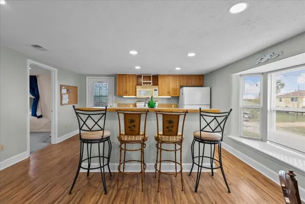 a kitchen with granite countertop wooden floor stainless steel appliances and dining table
