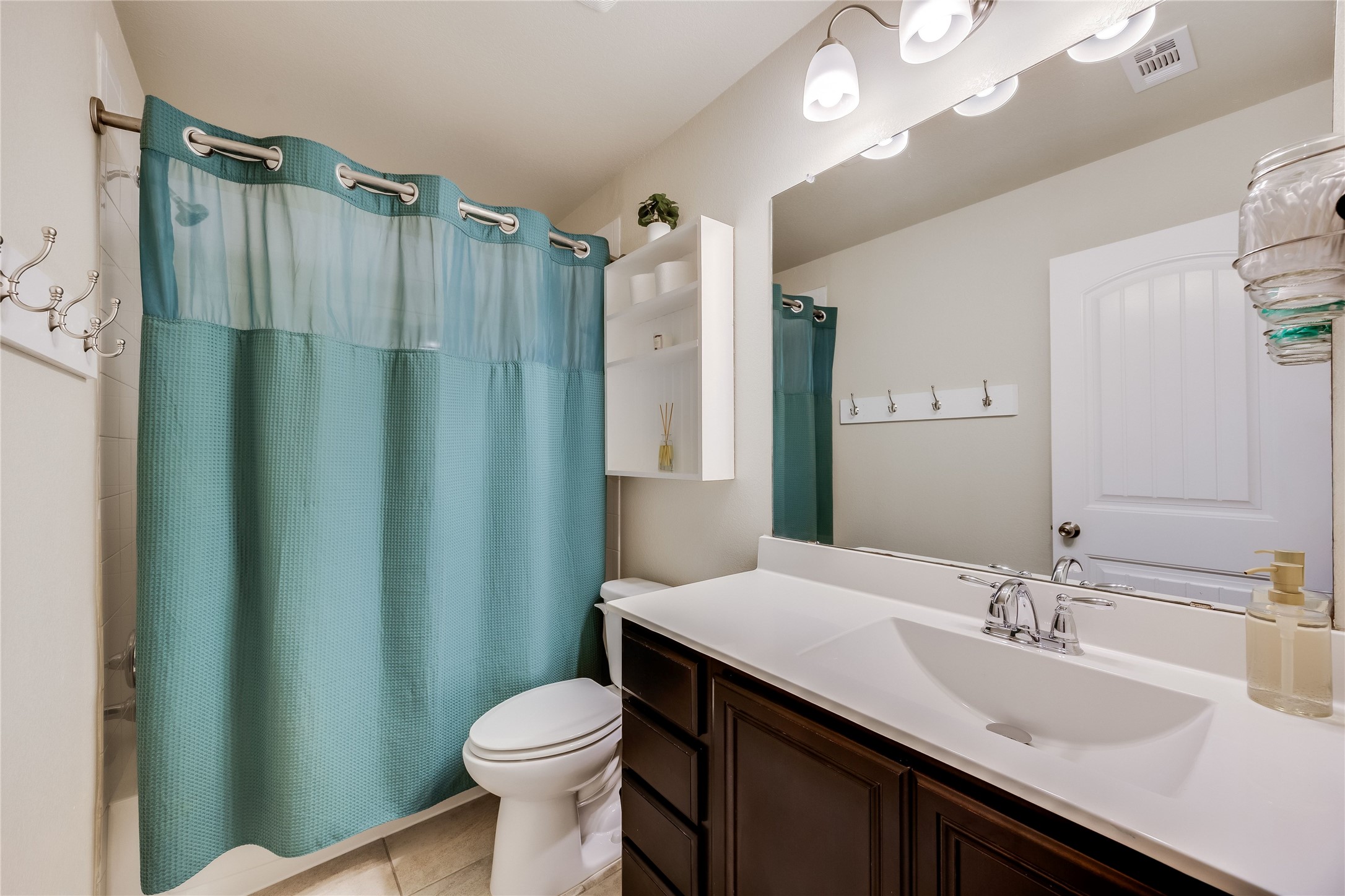 11328 Reading Way Austin, TX 78717 - Photo 25 of 37 a bathroom with a sink a toilet a mirror and shower curtain
