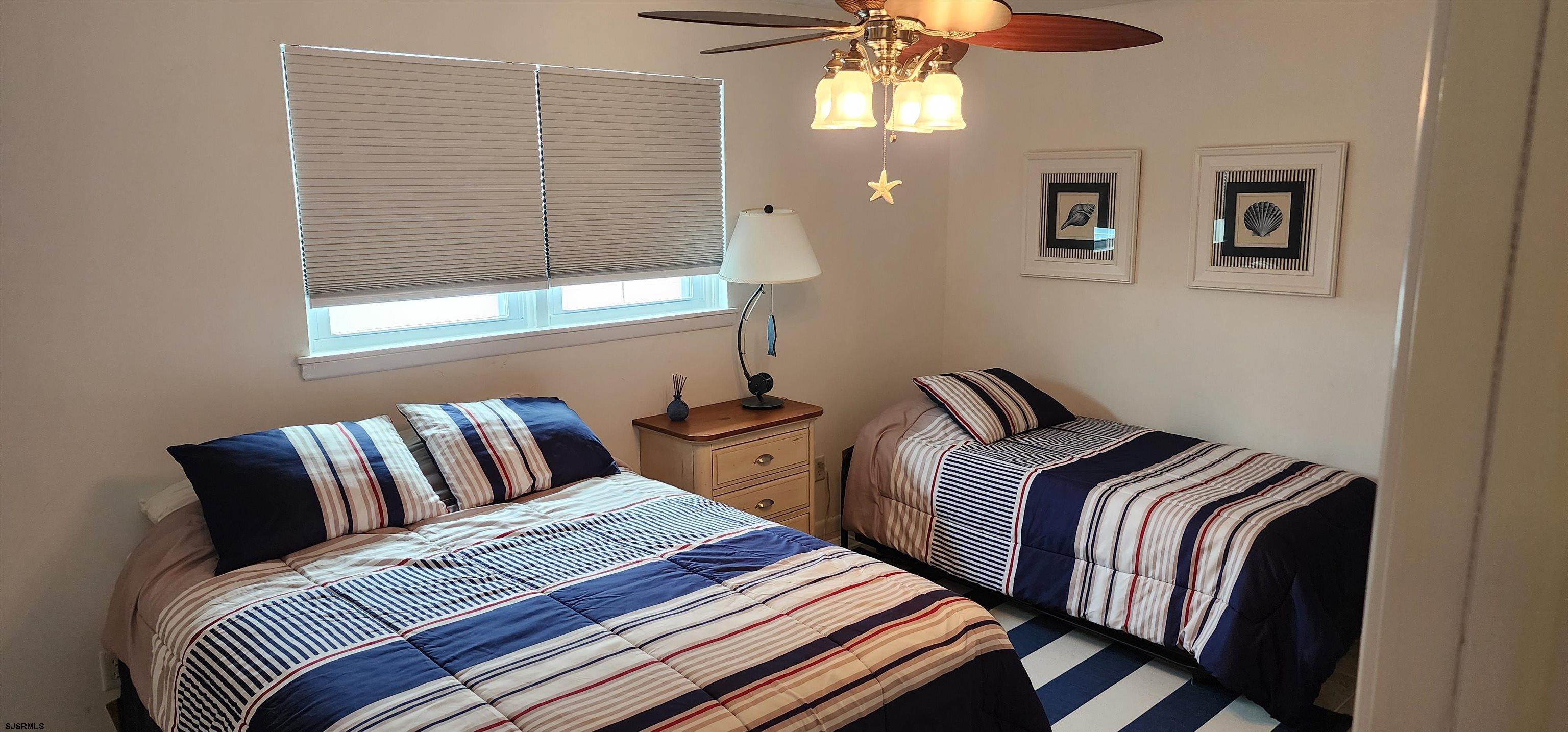 4313 West Brigantine Avenue, Unit 3 Brigantine, NJ 08203 - Photo 11 of 15 a bedroom with two beds and a chandelier