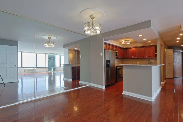 a view of a kitchen with a refrigerator wooden floor and a kitchen