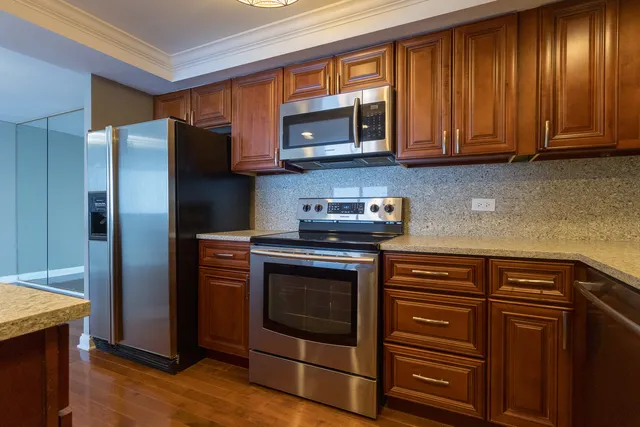 a kitchen with stainless steel appliances granite countertop a refrigerator microwave and sink