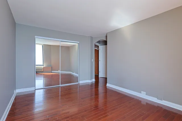 a view of empty room with wooden floor