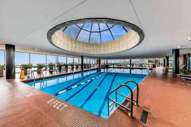 a living room with furniture a chandelier and wooden floor