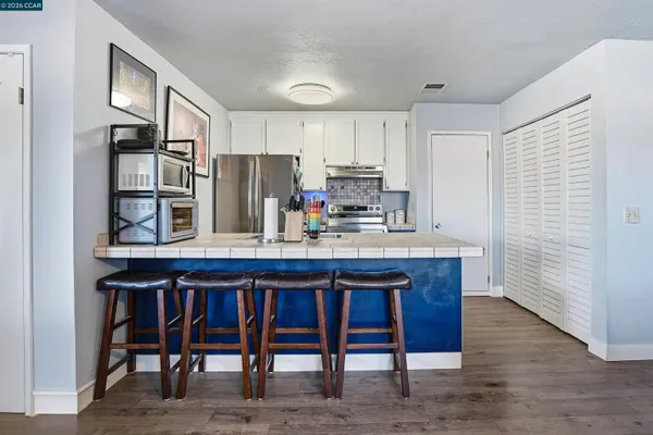 a kitchen with a table chairs refrigerator and cabinets