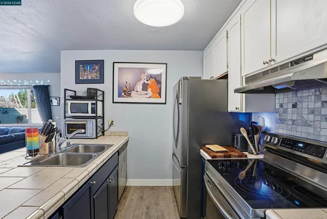 a kitchen with stainless steel appliances granite countertop a refrigerator and a stove top oven