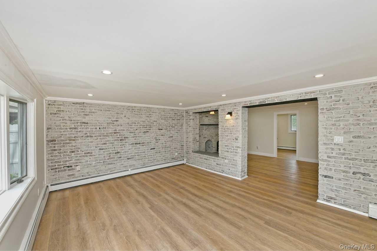 107 Beverly Road Massapequa, NY 11758 - Photo 24 of 41 wooden floor in an empty room with a window