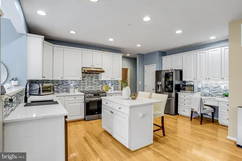 a kitchen with a sink a counter top space stainless steel appliances and cabinets