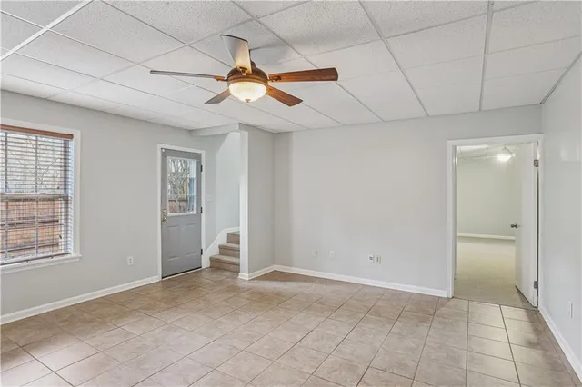 an empty room with windows and fan