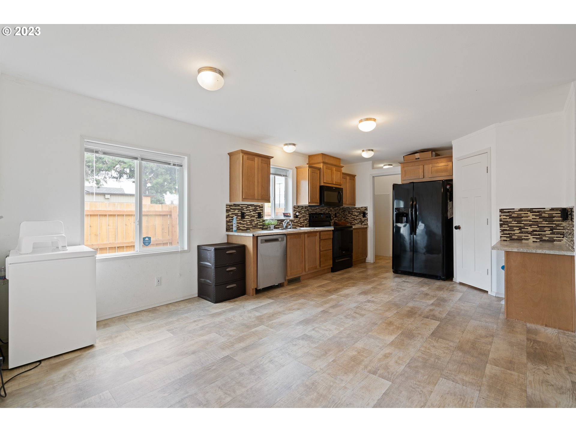 1383 Taney Street Eugene, OR 97402 - Photo 4 of 23 a large white kitchen with a refrigerator a stove a sink a dining table and chair