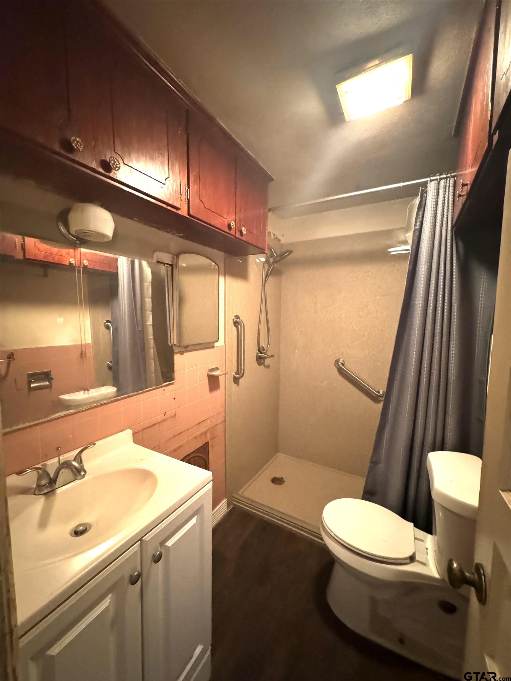 2017 West Jackson Street Tyler, TX 75701 - Photo 15 of 24 a bathroom with a sink a toilet a mirror and shower