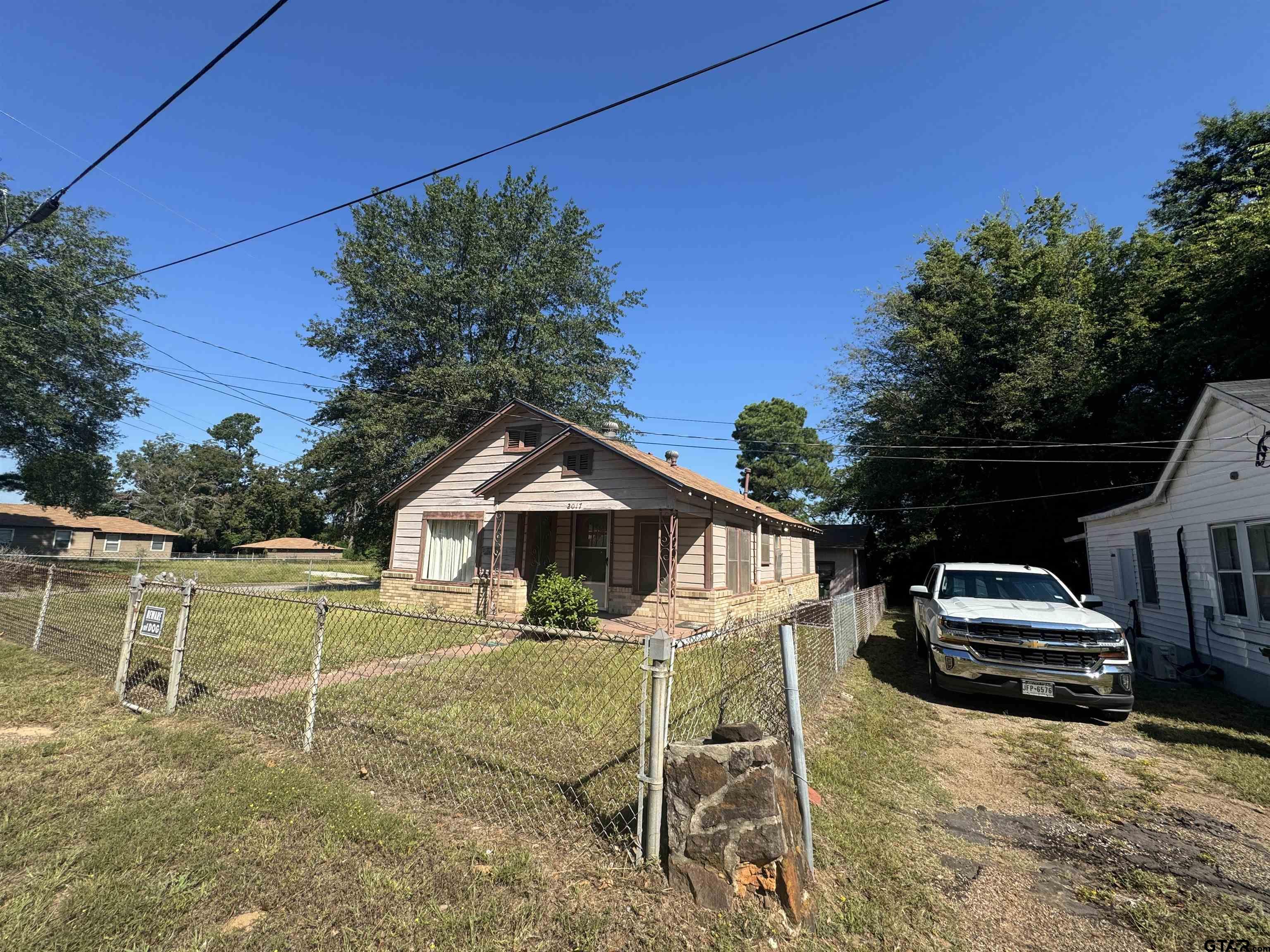 2017 West Jackson Street Tyler, TX 75701 - Photo 18 of 24 a white house with a yard and table under an umbrella