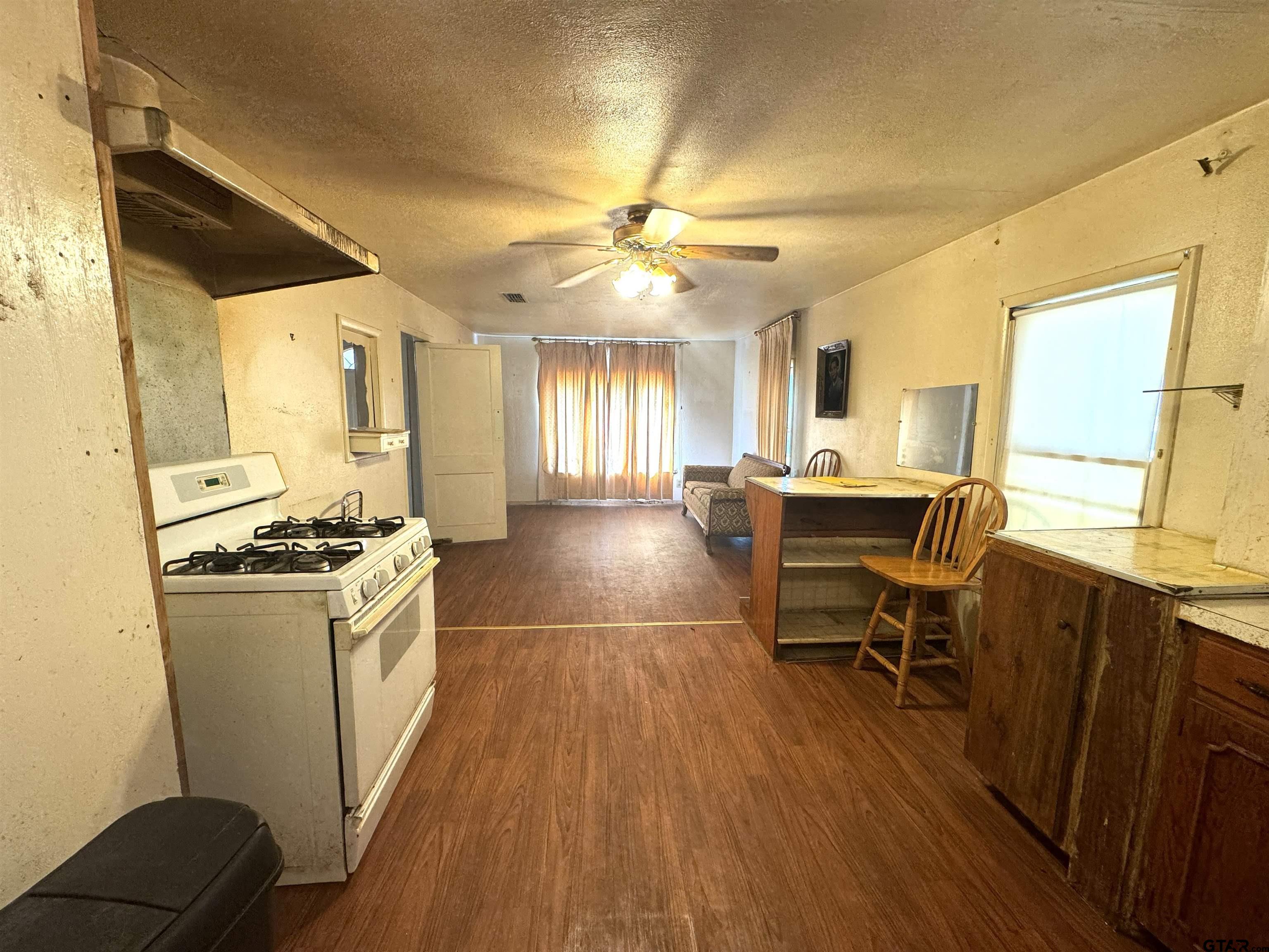 2017 West Jackson Street Tyler, TX 75701 - Photo 5 of 24 a kitchen with stainless steel appliances granite countertop a stove a refrigerator a dining table and chairs with wooden floor