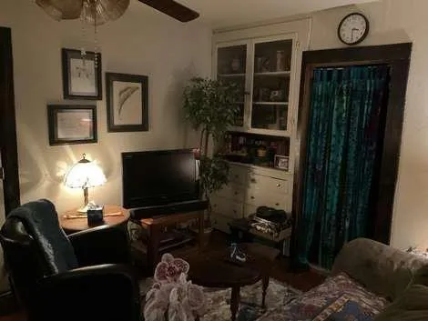 a bedroom with a bed and a flat tv screen on dresser