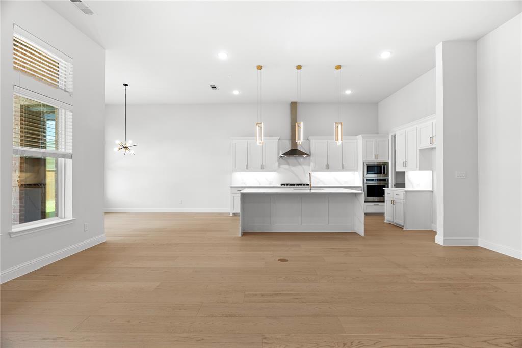 4405 Rosedale Street Prosper, TX 75078 - Photo 38 of 40 a large kitchen with kitchen island a stove a sink dishwasher and a refrigerator