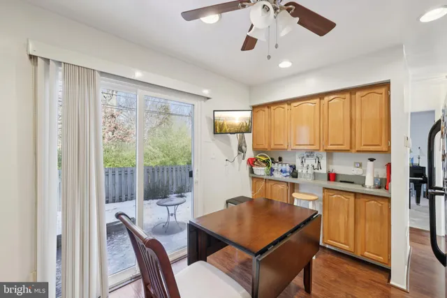 a dining room with stainless steel appliances granite countertop a refrigerator a stove a sink dishwasher a dining table and chairs with wooden floor