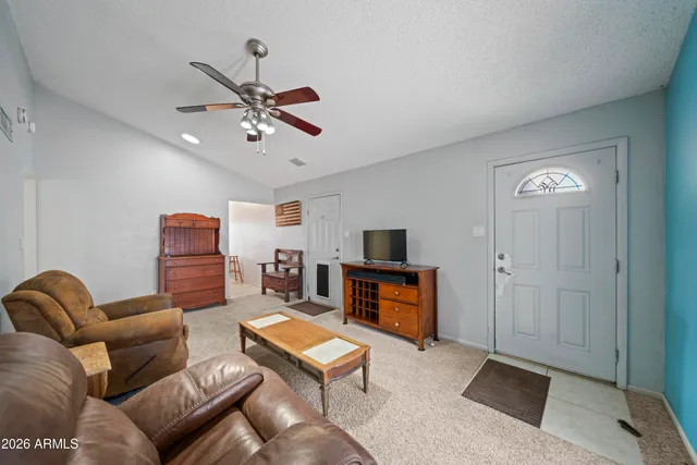 a living room with furniture and a ceiling fan