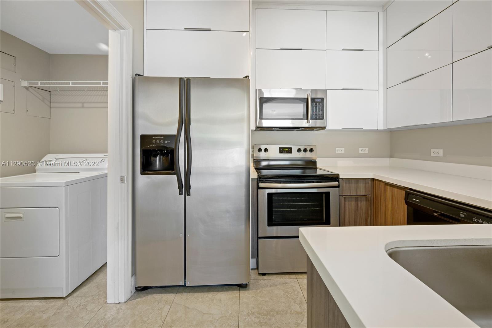9172 Collins Avenue, Unit 403 Surfside, FL 33154 - Photo 11 of 30 a kitchen with stainless steel appliances a refrigerator stove and microwave