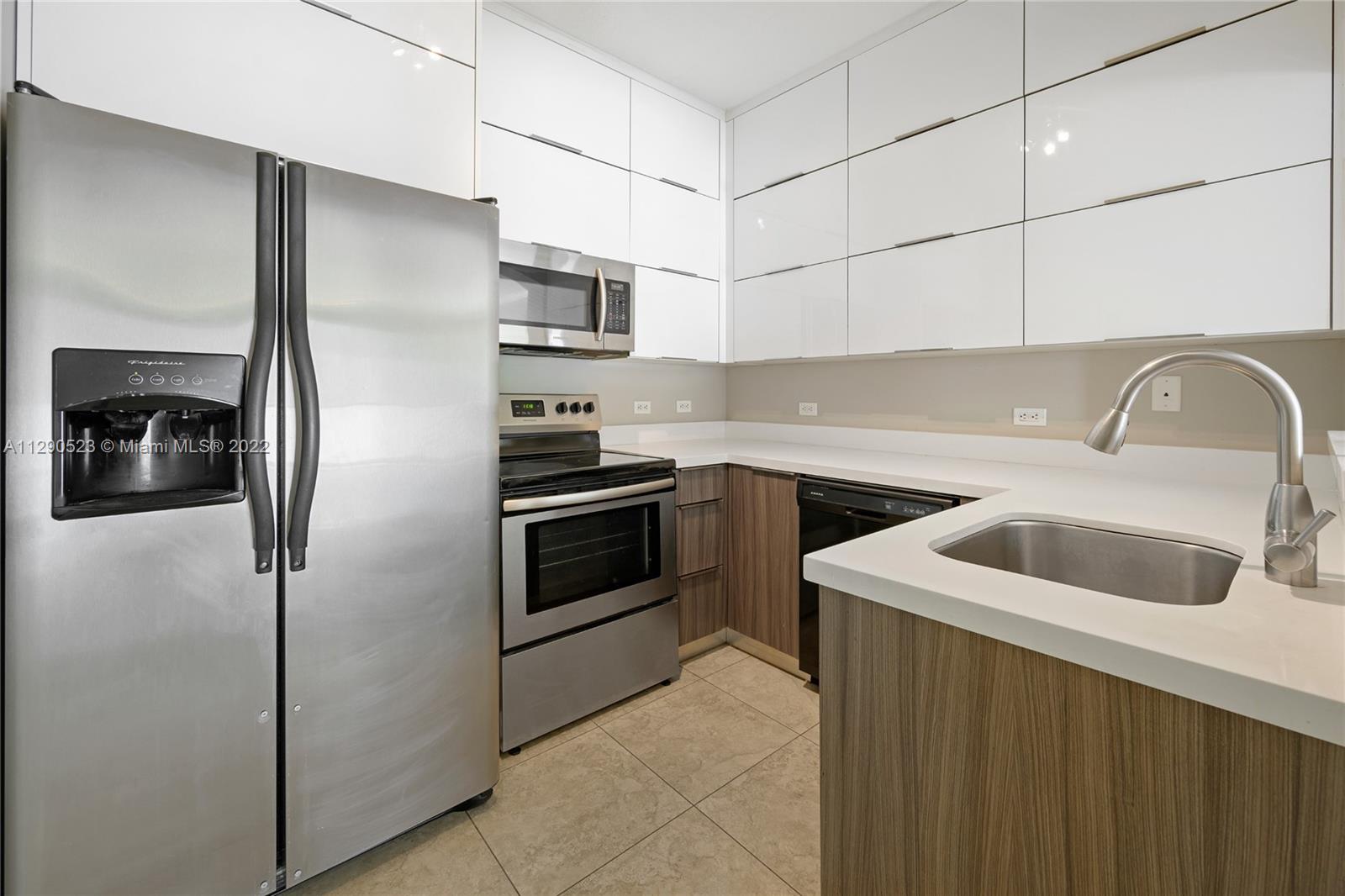 9172 Collins Avenue, Unit 403 Surfside, FL 33154 - Photo 12 of 30 a kitchen with stainless steel appliances granite countertop a refrigerator sink and stove