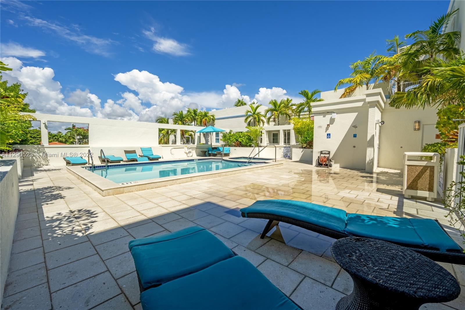 9172 Collins Avenue, Unit 403 Surfside, FL 33154 - Photo 25 of 30 a swimming pool with outdoor seating and yard