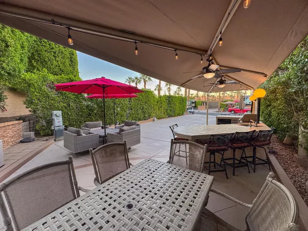a view of a patio with a table and chairs under an umbrella