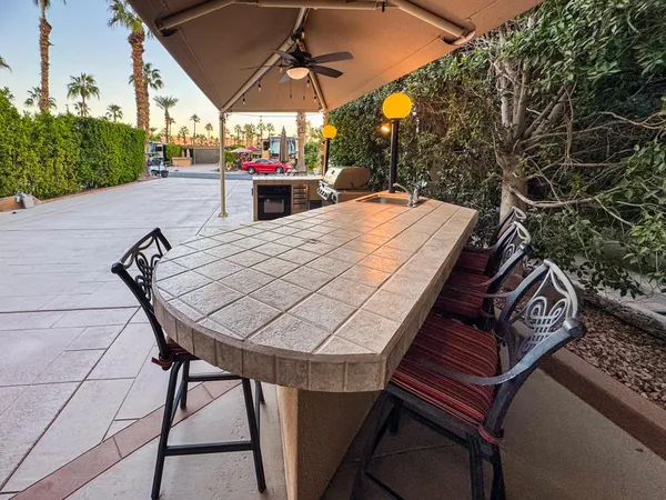 a view of a patio with table and chairs under an umbrella