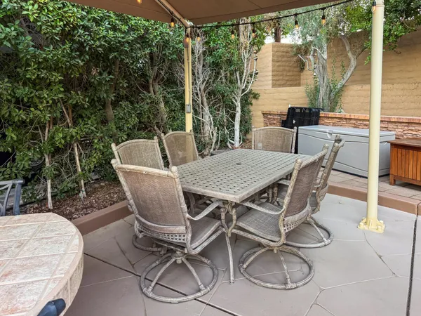 a view of a patio with table and chairs with wooden floor and fence