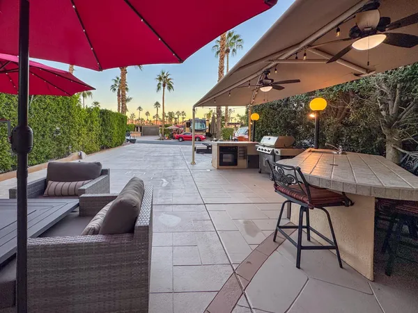 a view of a patio with a table and chairs under an umbrella