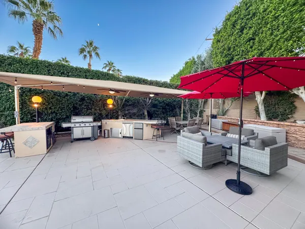 a view of a patio with a table and chairs under an umbrella