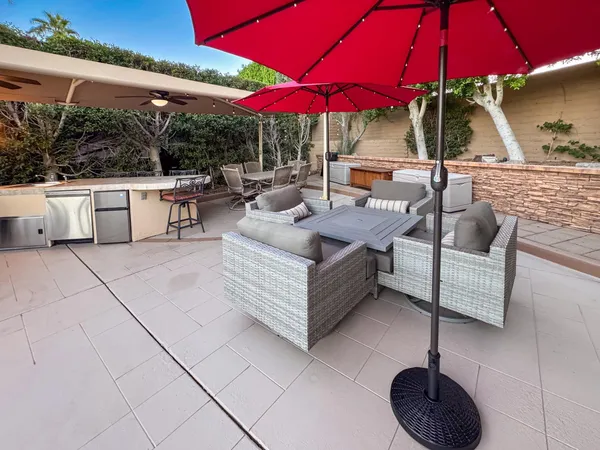 a view of a patio with a table and chairs under an umbrella