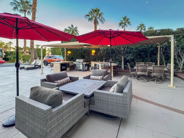 a view of a patio with couches and umbrella