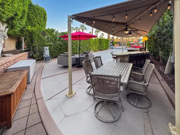 a view of a patio with a table and chairs under an umbrella