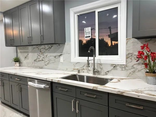 a kitchen with granite countertop stainless steel appliances sink and cabinets