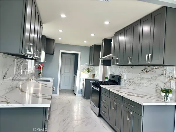 a kitchen with stainless steel appliances granite countertop a sink stove and cabinets
