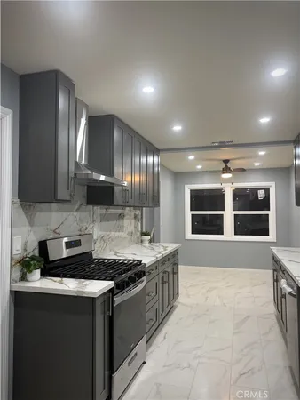 a large kitchen with kitchen island a sink stainless steel appliances and cabinets