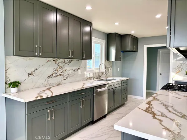 a kitchen with stainless steel appliances granite countertop a sink a stove and a refrigerator