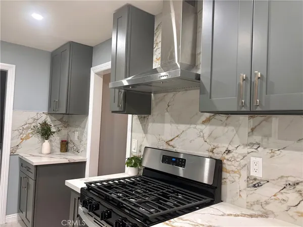 a kitchen with granite countertop a sink stove and cabinets