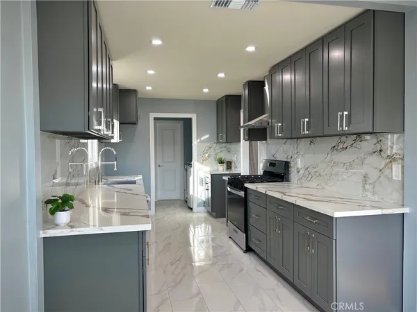 a kitchen with stainless steel appliances granite countertop a sink a stove and a refrigerator