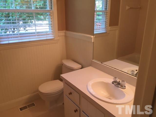 7909 Harps Mill Road Raleigh, NC 27615 - Photo 14 of 25 a bathroom with a sink a toilet and a mirror