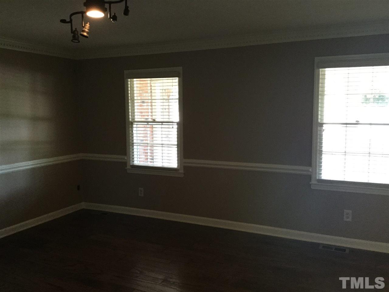 7909 Harps Mill Road Raleigh, NC 27615 - Photo 8 of 25 a view of an empty room with wooden floor and a window