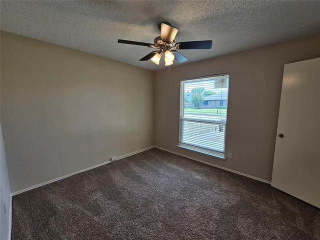 an empty room with closet and a chandelier fan