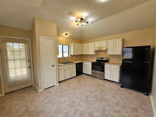 a kitchen with a refrigerator and a stove top oven