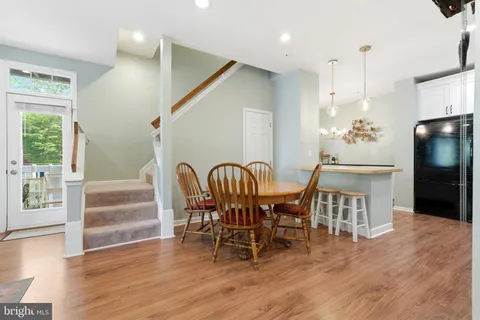 a dining room with furniture entryway and wooden floor