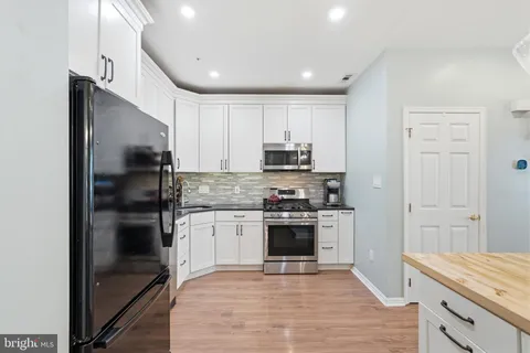 a kitchen with stainless steel appliances granite countertop a refrigerator and a stove top oven