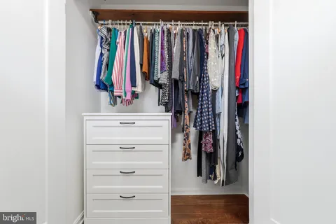 a view of walk in closet with clothes and shoes