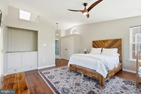 a bedroom with a bed and dresser with rug