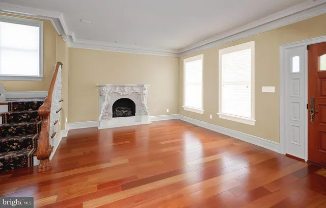 a view of empty room with wooden floor and fireplace