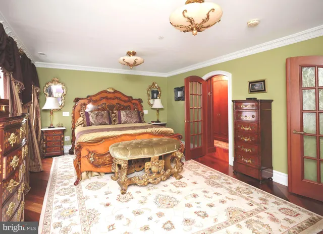 a spacious bedroom with a bed and a dresser with mirror
